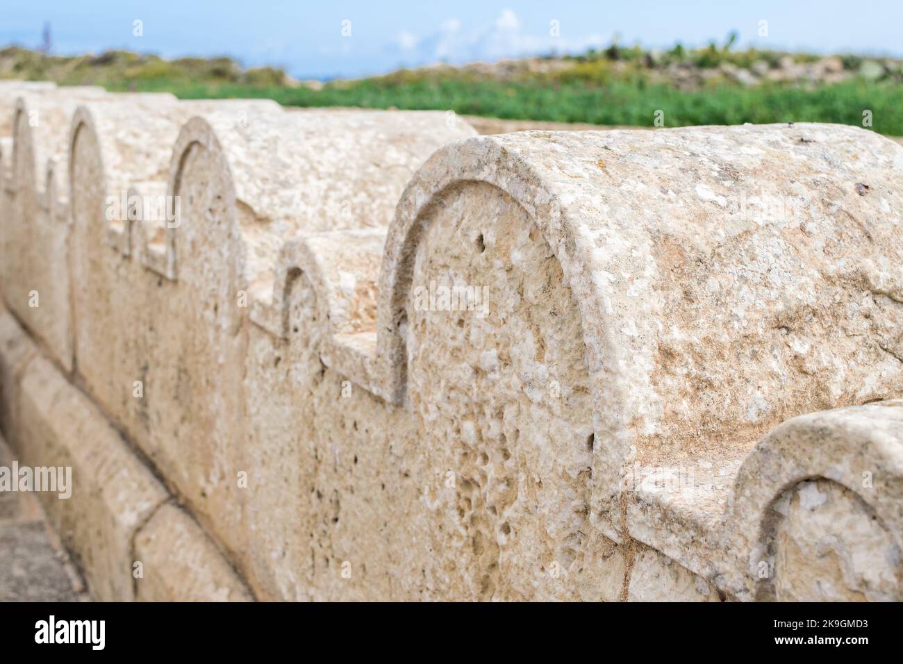 Ein Kalksteinzaun oder eine Grenze, die mit kleinen und großen Steinbögen um die St. Dimitri-Kapelle im ländlichen Dorf Gharb, Gozo, Malta, geschmückt ist Stockfoto