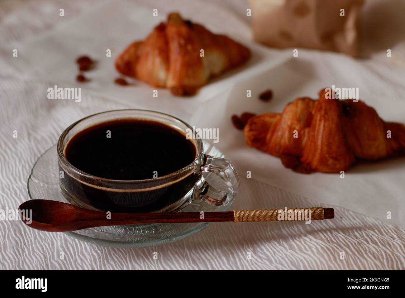 Konzentrieren Sie sich auf eine Tasse schwarzen Kaffee und frisch gebackene Croissants für ein einfaches französisches Frühstück Stockfoto