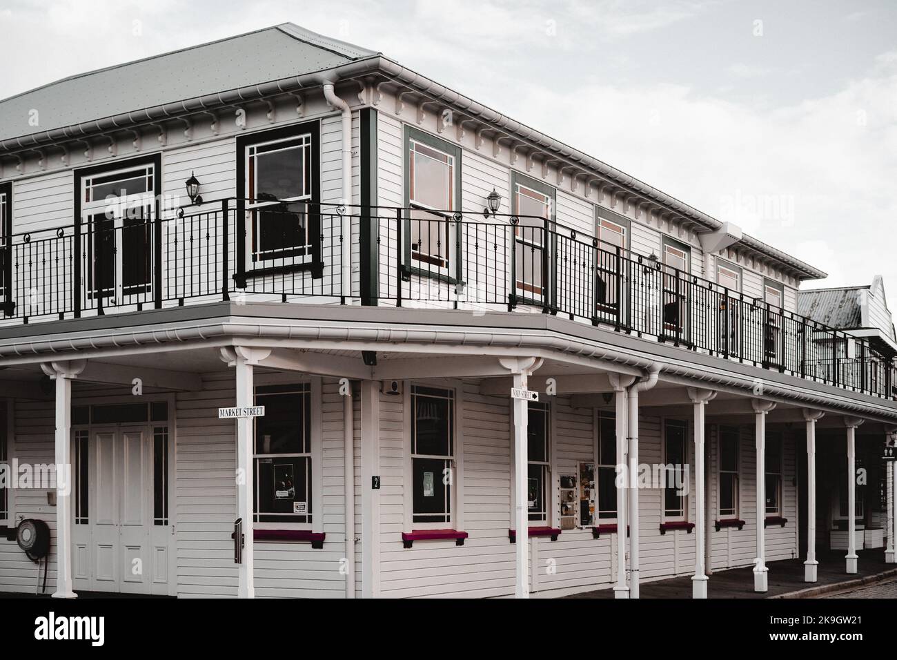 Holzgebäude auf der Marktstraße mit vielen gleichen quadratischen Fenstern und schönen Straßenlampen in einer ruhigen und einsamen Nachbarschaft einer kleinen Stadt, westlich Stockfoto