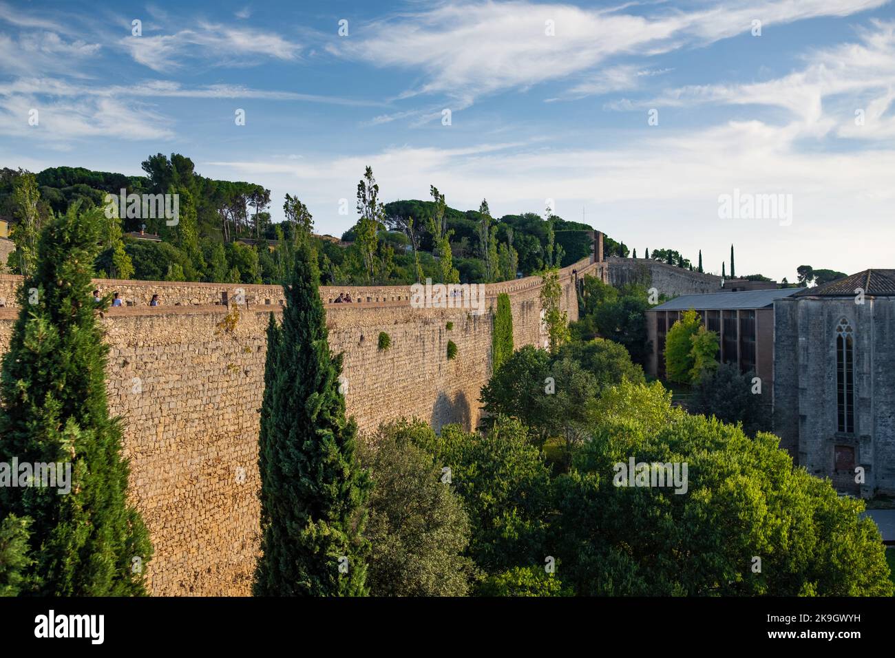 Girona, Spanien, 22. Oktober 2022: Spaziergang durch die alten Stadtmauern von Girona an sonnigen Sommertagen, bekannt als Passeig de la Muralla. Alte römische Mauern Stockfoto
