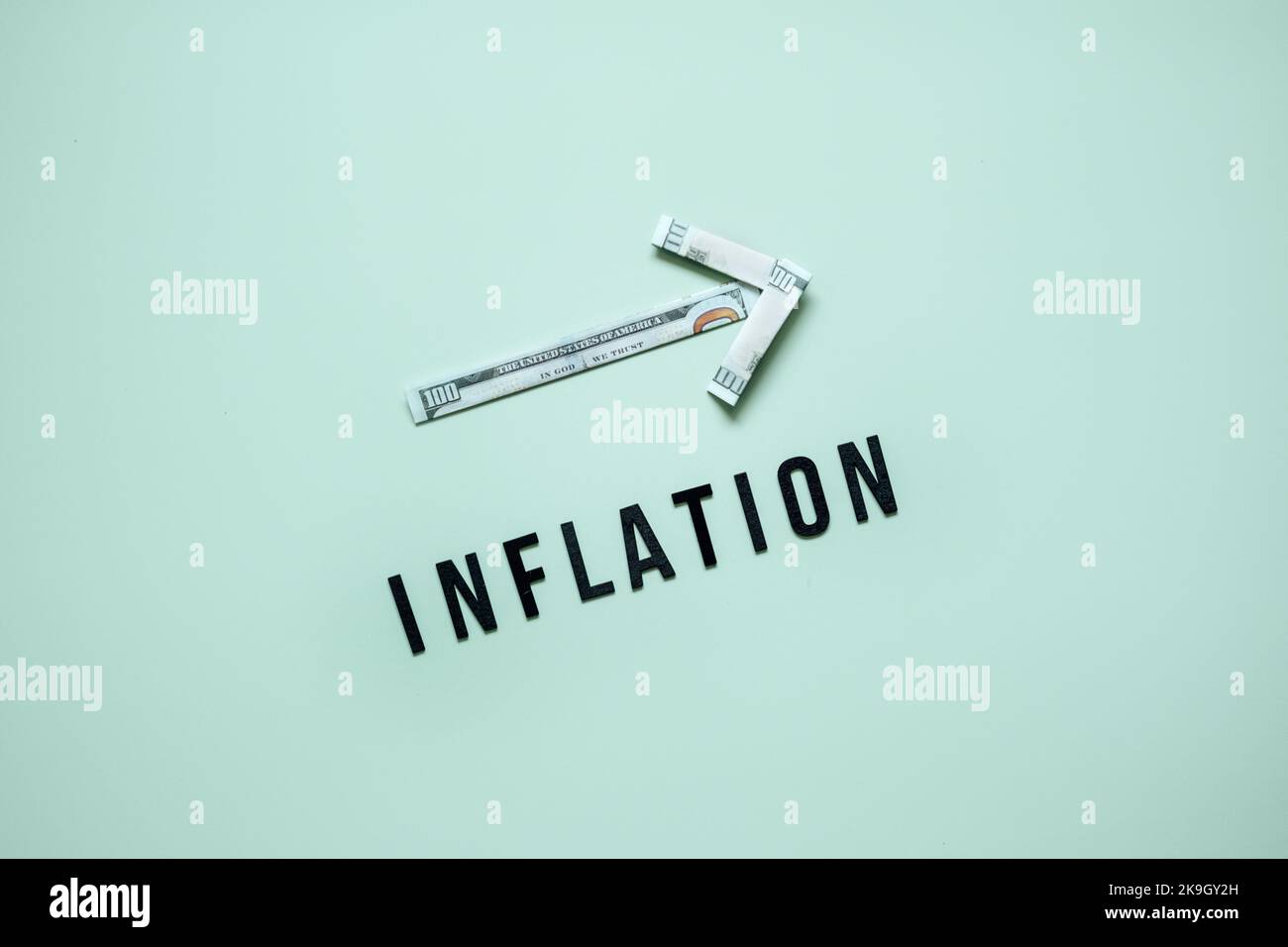 Konzept der Inflation in der Finanzkrise. Aufwärtspfeil von Dollar-Banknoten und Wortinflation auf blauem Hintergrund. Steigende Lebenshaltungskosten. Stockfoto