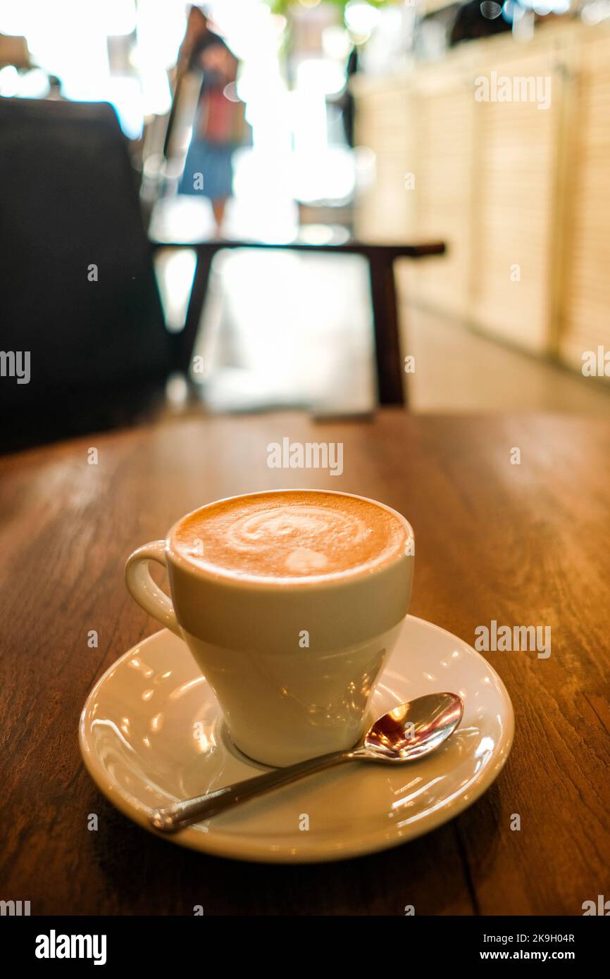 Flacher weißer Kaffee im Café-Ambiente mit weichem Bokeh-Hintergrund Stockfoto