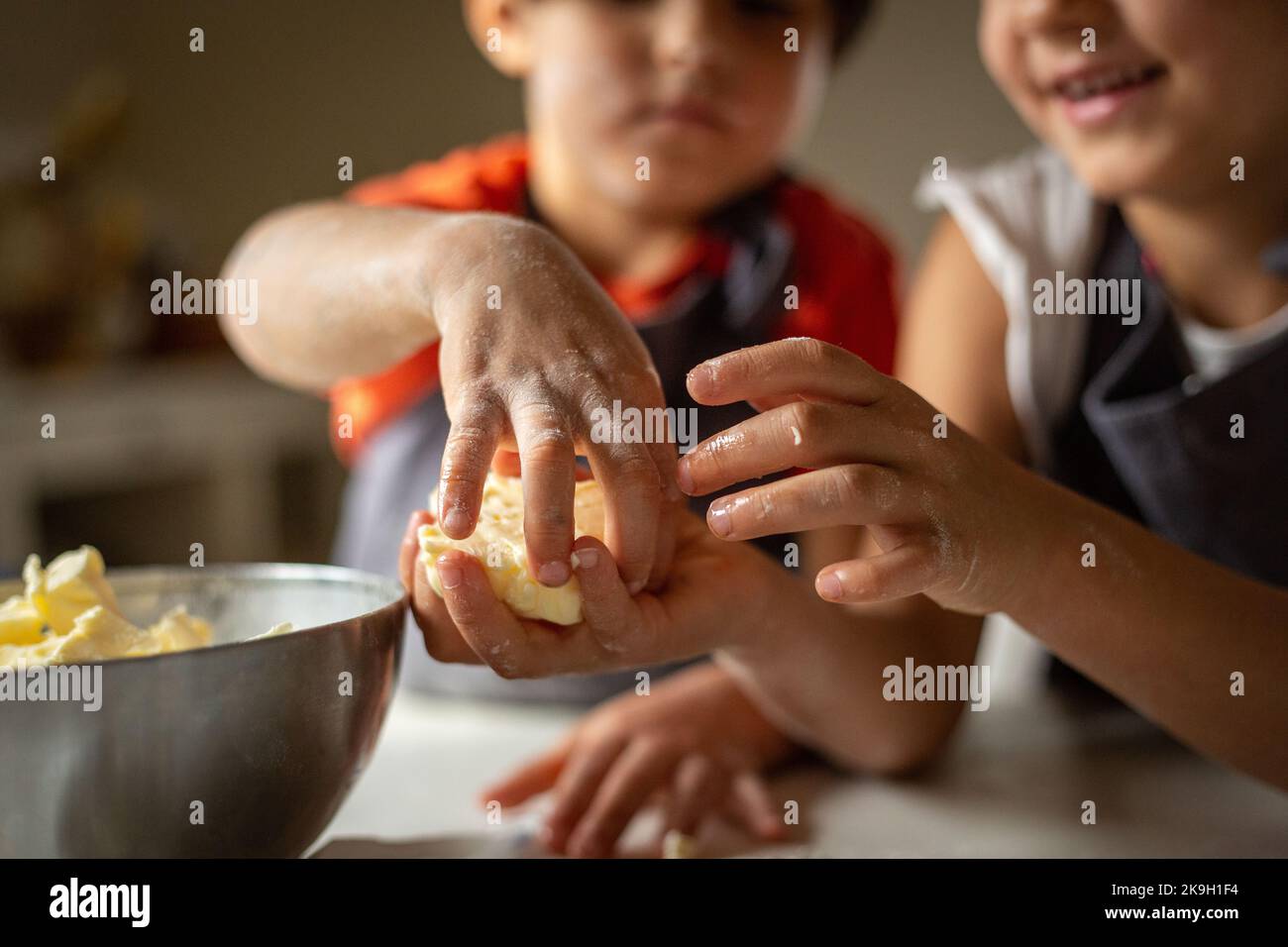 Nahansicht der Hände von Kindern, die Butter einlegen Stockfoto