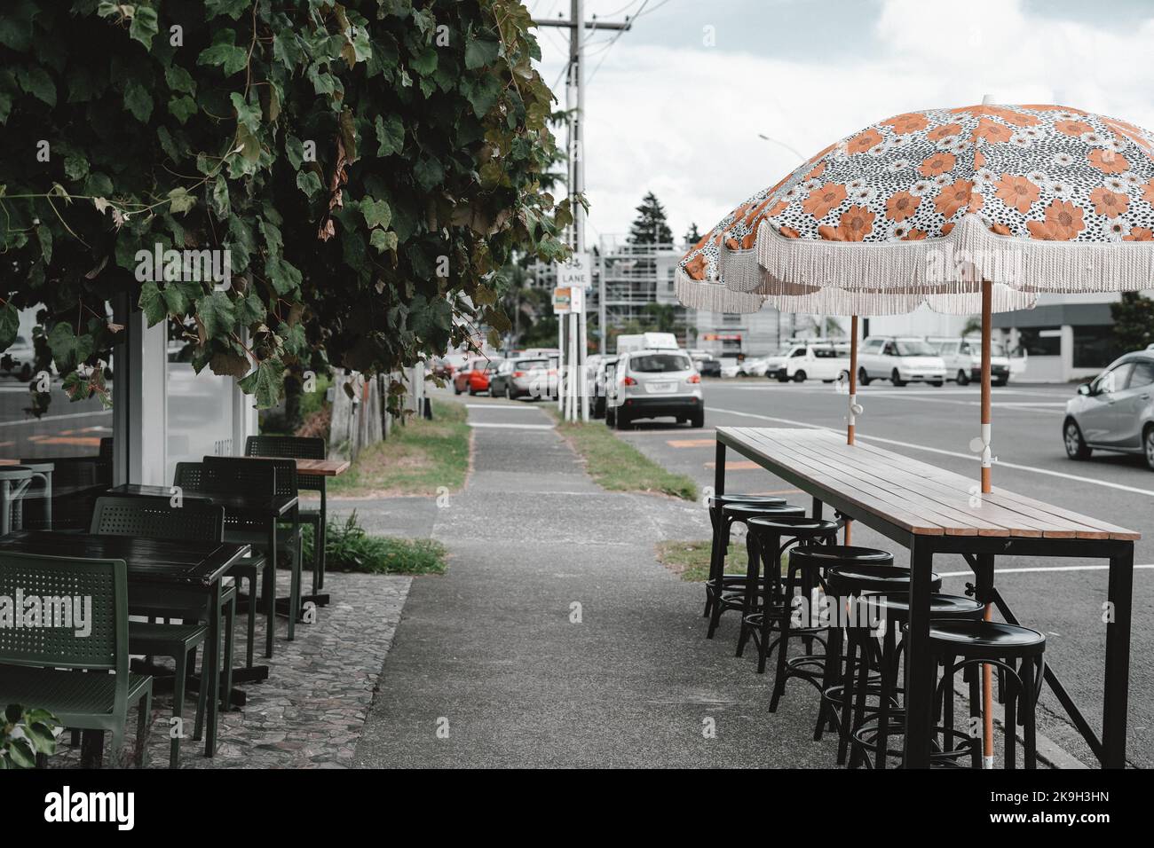 Tische, Stühle und Sonnenschirme vor dem Restaurant Stockfoto