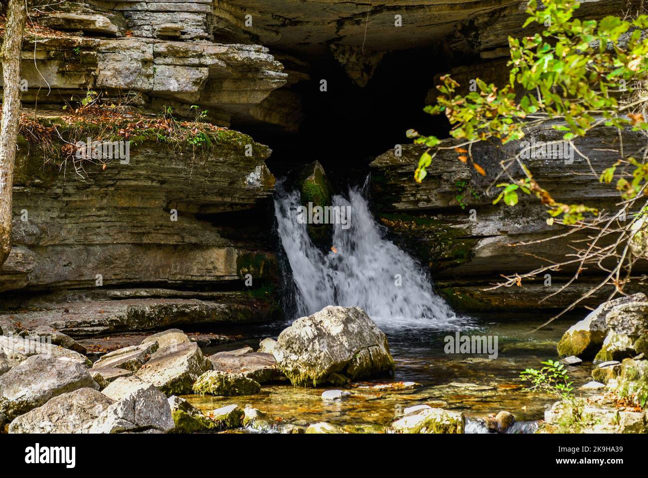 Bild einer Quelle, die aus einer Höhle kommt Stockfoto