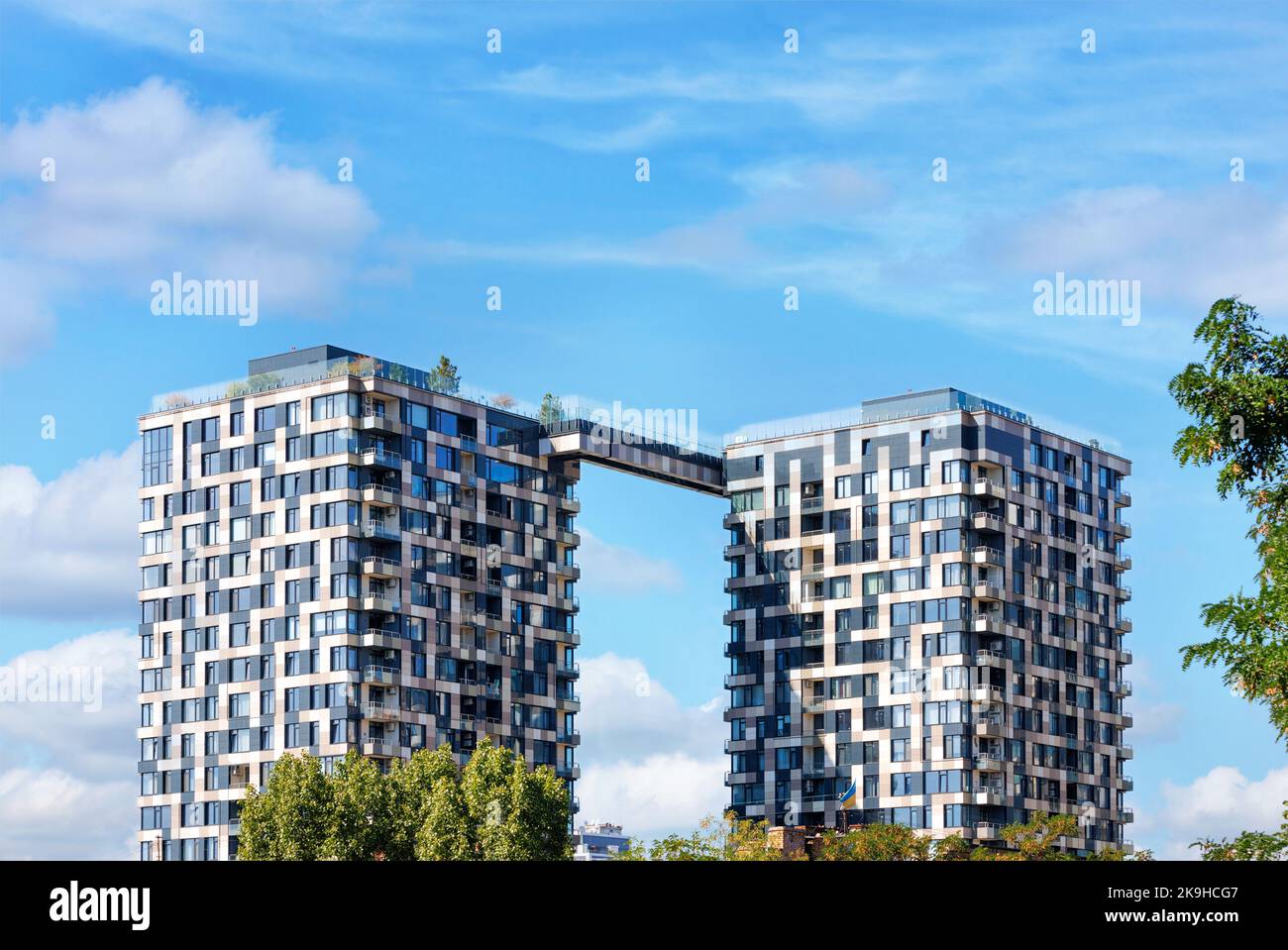 Pixel-Design der Fassade von mehrstöckigen Zwillingstürmen von Wohngebäuden gegen den blauen Sommerhimmel. Stockfoto