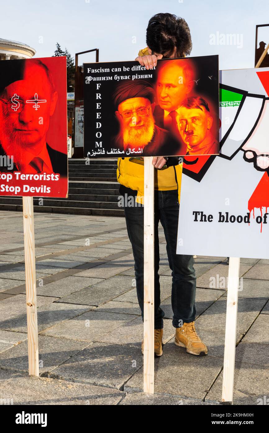 Kiew, Ukraine. 28. Oktober 2022. In der Nähe von Plakaten steht eine Frau, die Wladimir Putin, den obersten Herrscher des Iran Ali Khamenei und Adolf Hitler mit der Aufschrift „Faschismus kann anders sein“ zeigt. Die iranische Diaspora in der Ukraine protestierte gegen die Beteiligung des Iran an der russischen Aggression. Vertreter der iranischen Gemeinschaft in der Ukraine erklärten, dass sie sich gegen das Vorgehen der iranischen Behörden aussprechen, die Putins diktatorisches Regime im Krieg gegen die Ukraine unterstützen. Kredit: SOPA Images Limited/Alamy Live Nachrichten Stockfoto