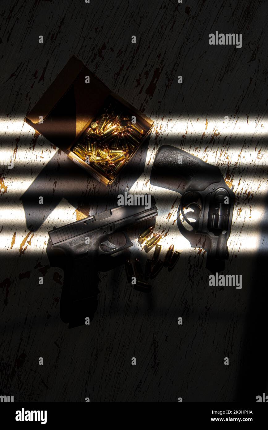 Eine schwarze Glock 19, 9mm, eine Pistole und eine Ruger, 9mm, stumpfe Nase, einen Revolver auf einem Holztisch, zusammen mit ein paar Kugeln. Stockfoto