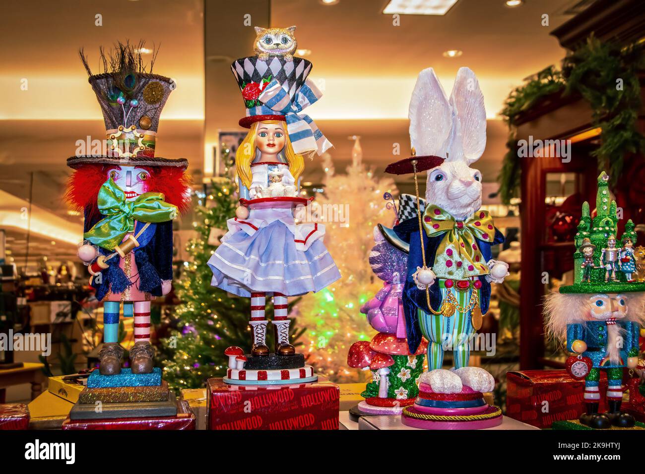 12-17-2021 Tulsa USA Alice im Wunderland Weihnachtsfiguren und Nussknacker im Kaufhaus mit verschwommenen Weihnachtsbäumen im Hintergrund Stockfoto