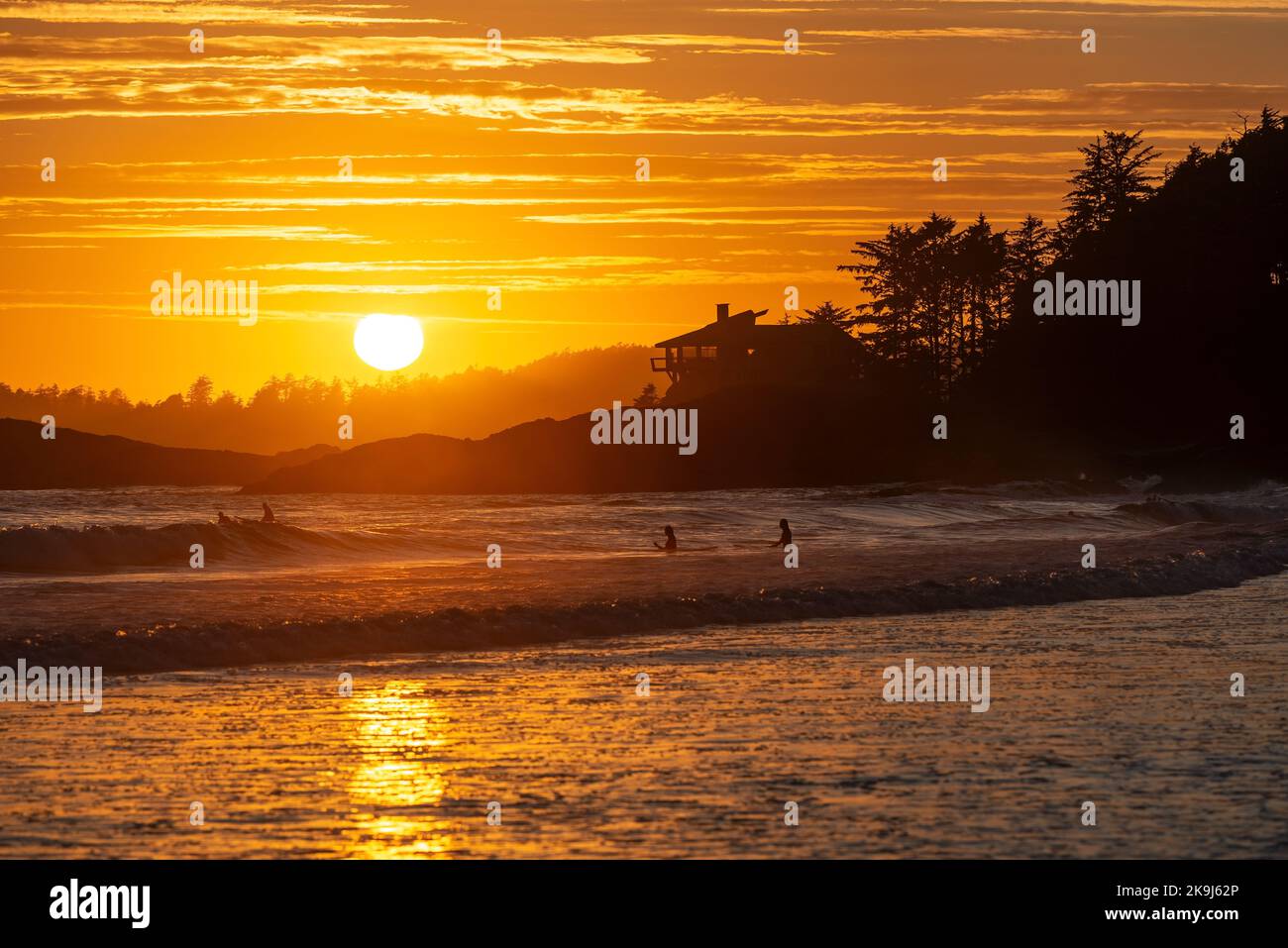 Sonnenuntergang am Chesterman Beach mit Surfern im Pazifik, Tofino, British Columbia, Kanada. Stockfoto