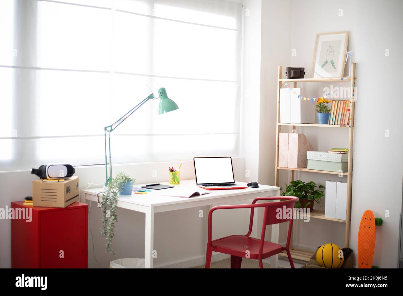 Gemütliches Zimmer für Teenager mit Schreibtisch, Stuhl und Schulbedarf Stockfoto