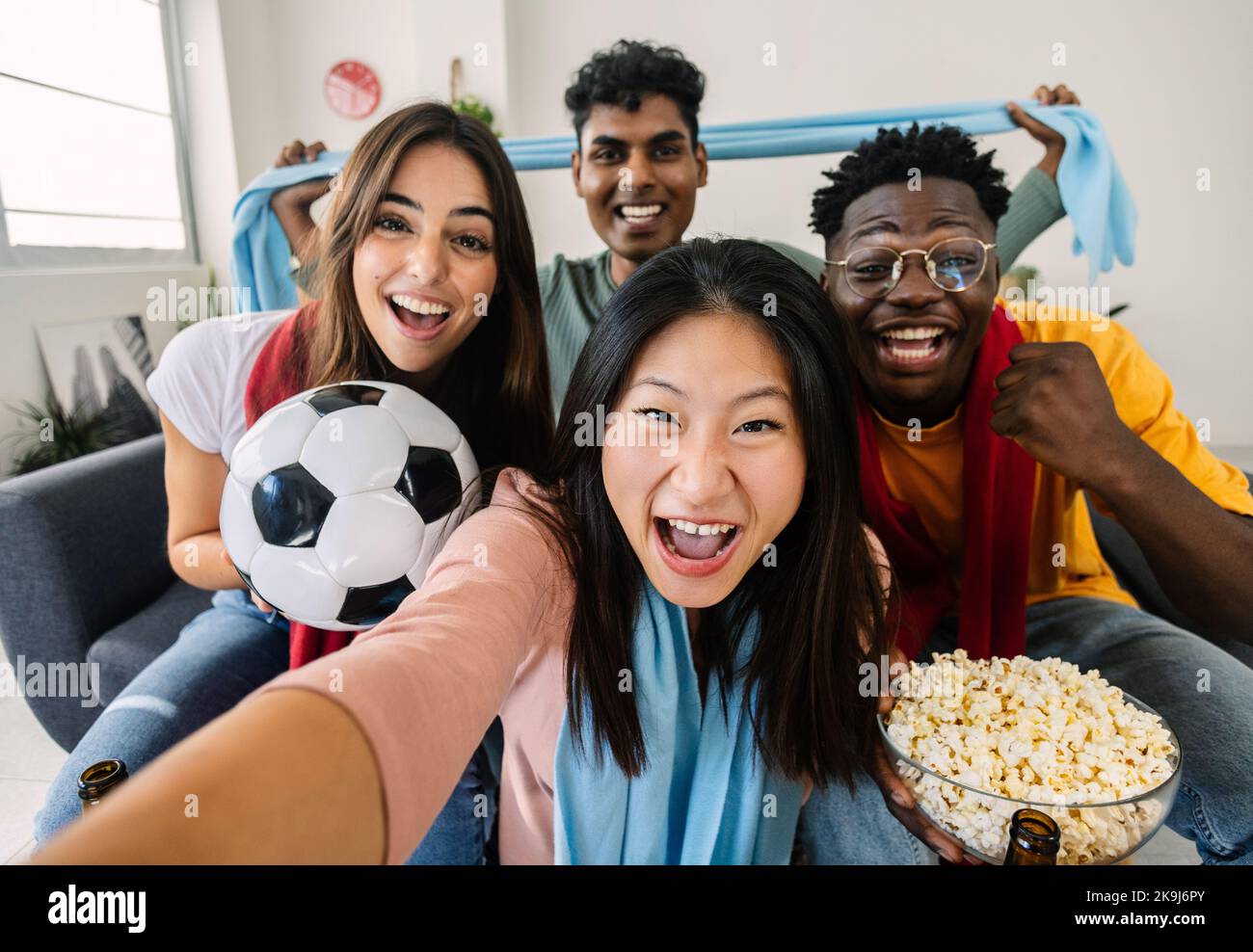 Aufgeregt multirassische junge Freunde, die Selfie machen, während sie Fußball im Fernsehen sehen Stockfoto