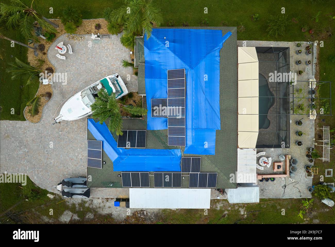 Luftaufnahme des beschädigten Hausdachs von Hurrikan Ian, das mit einer blauen Schutzplane gegen austretendes Regenwasser bedeckt ist, bis die Asphaltschindeln ersetzt wurden. Stockfoto