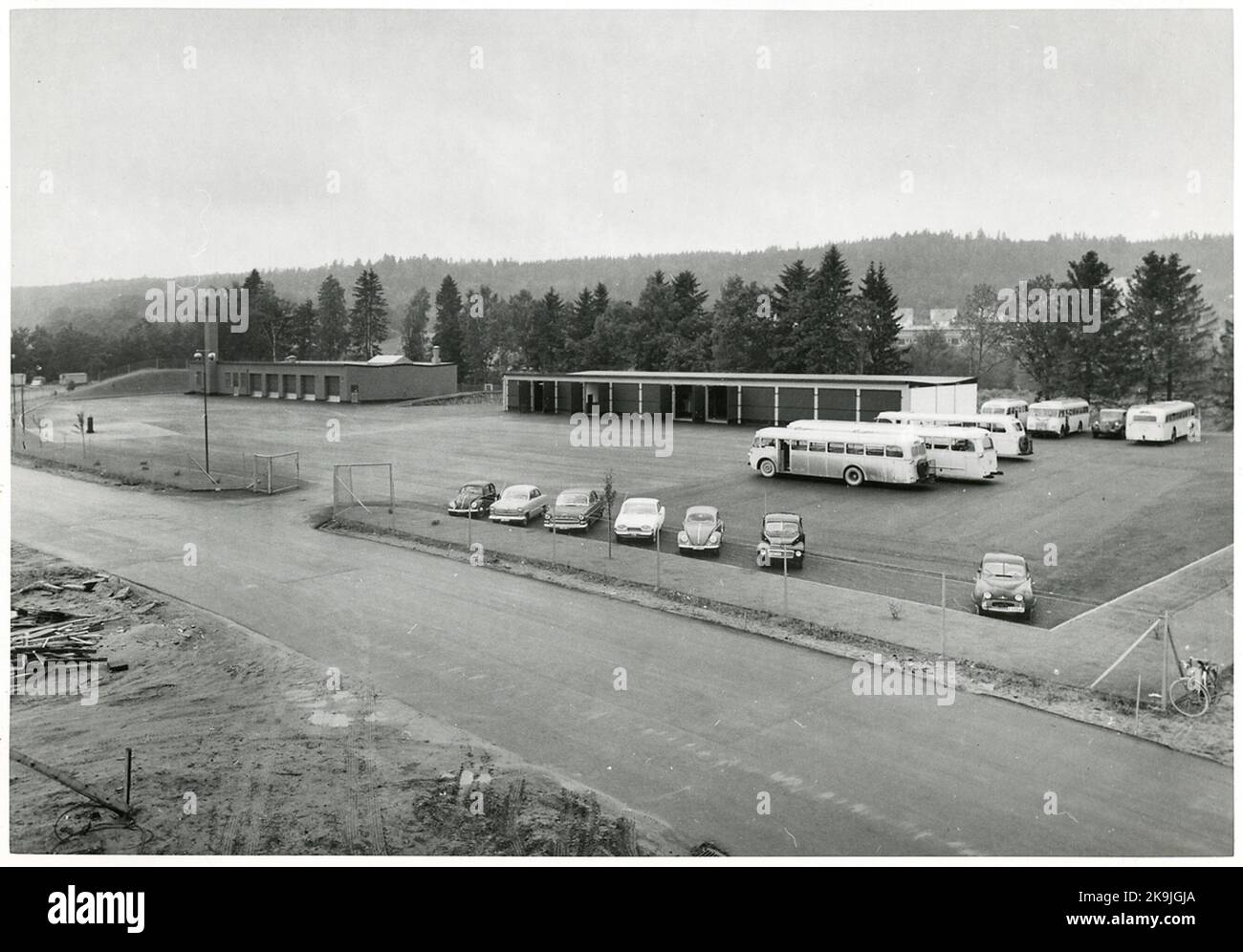 Busse und Autos werden in der Busgarage und Werkstatt geparkt. Stockfoto