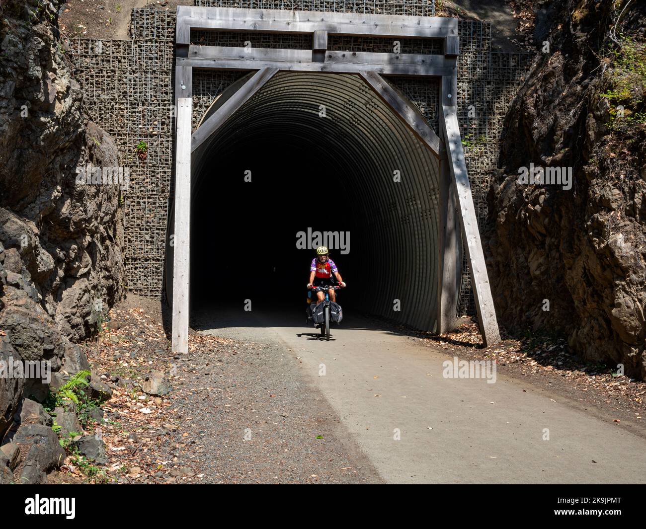 WA22650-00...WASHINGTON - Radler verlässt den McPhee Tunnel auf dem Olympic Discovery Trail am Ufer des Lake Crescent im Olympic National Park. Stockfoto