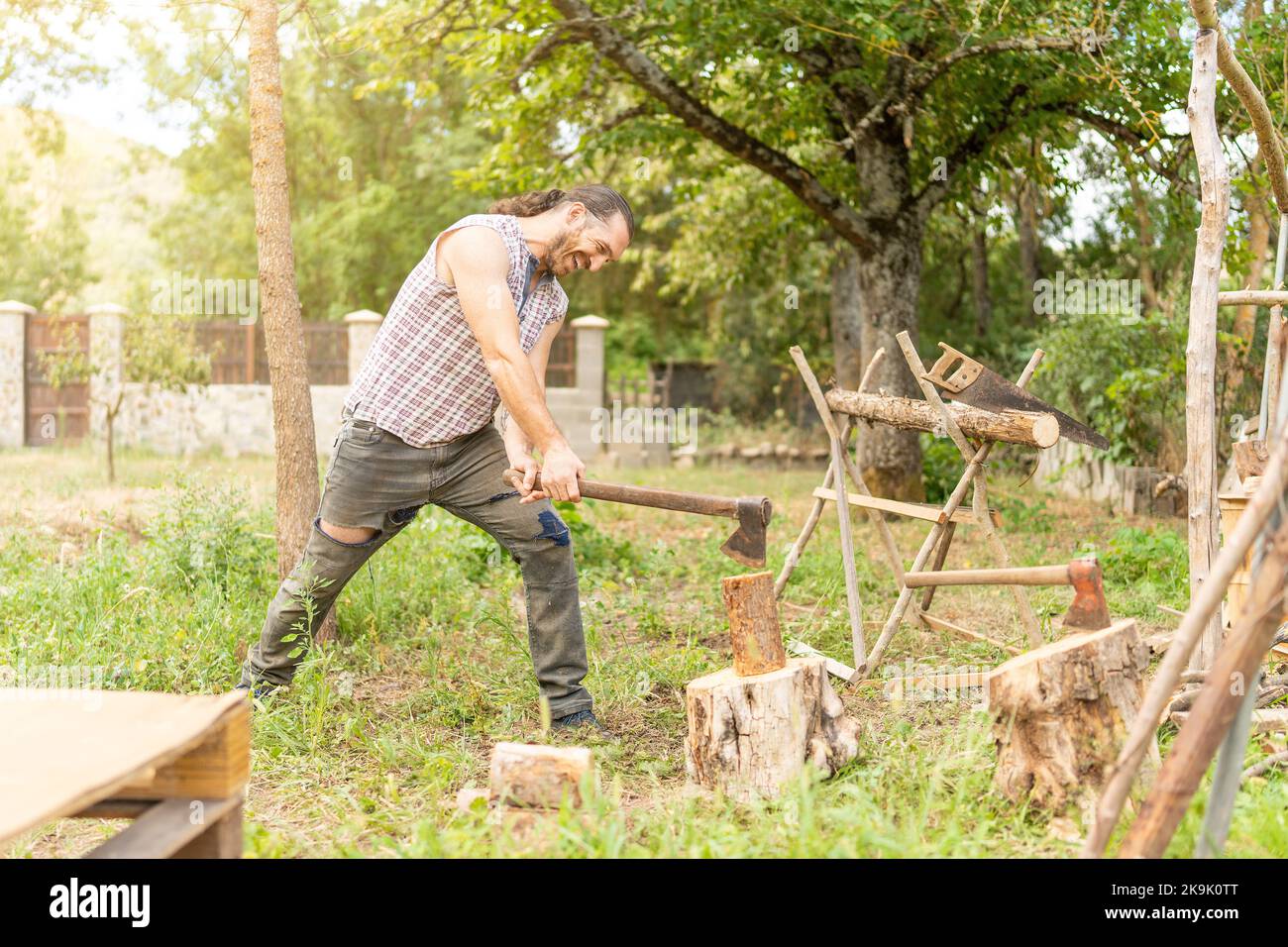 Mann hackt Holz mit einer Axt im Freien Stockfoto