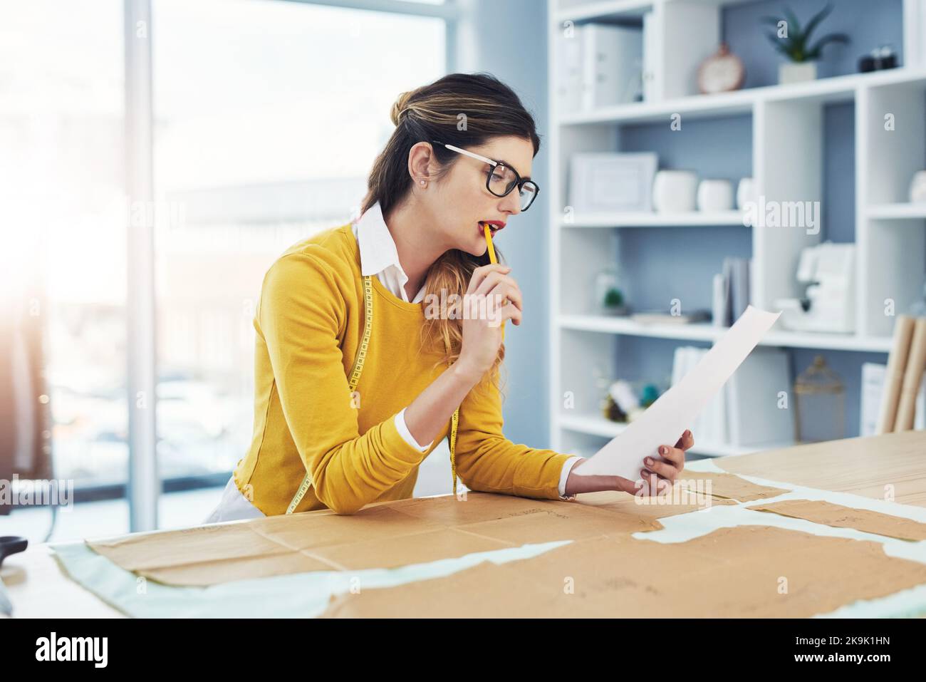 Kreativität ist ansteckend, weitergeben. Eine attraktive junge Modedesignerin in ihrer Werkstatt. Stockfoto