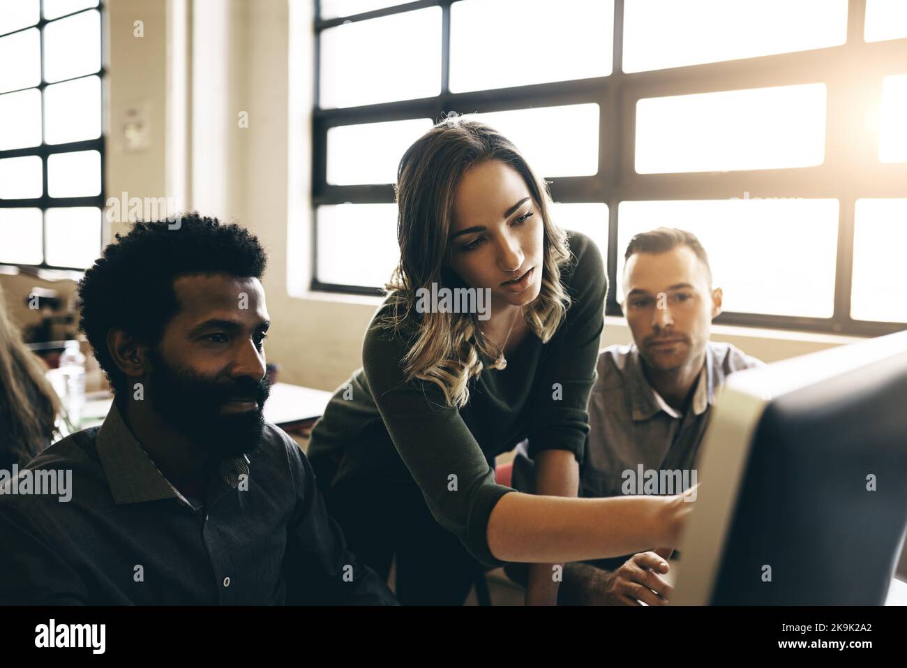 Ich habe eine einfachere Möglichkeit gefunden, dies zu tun... Kollegen diskutieren etwas auf einem Computer. Stockfoto