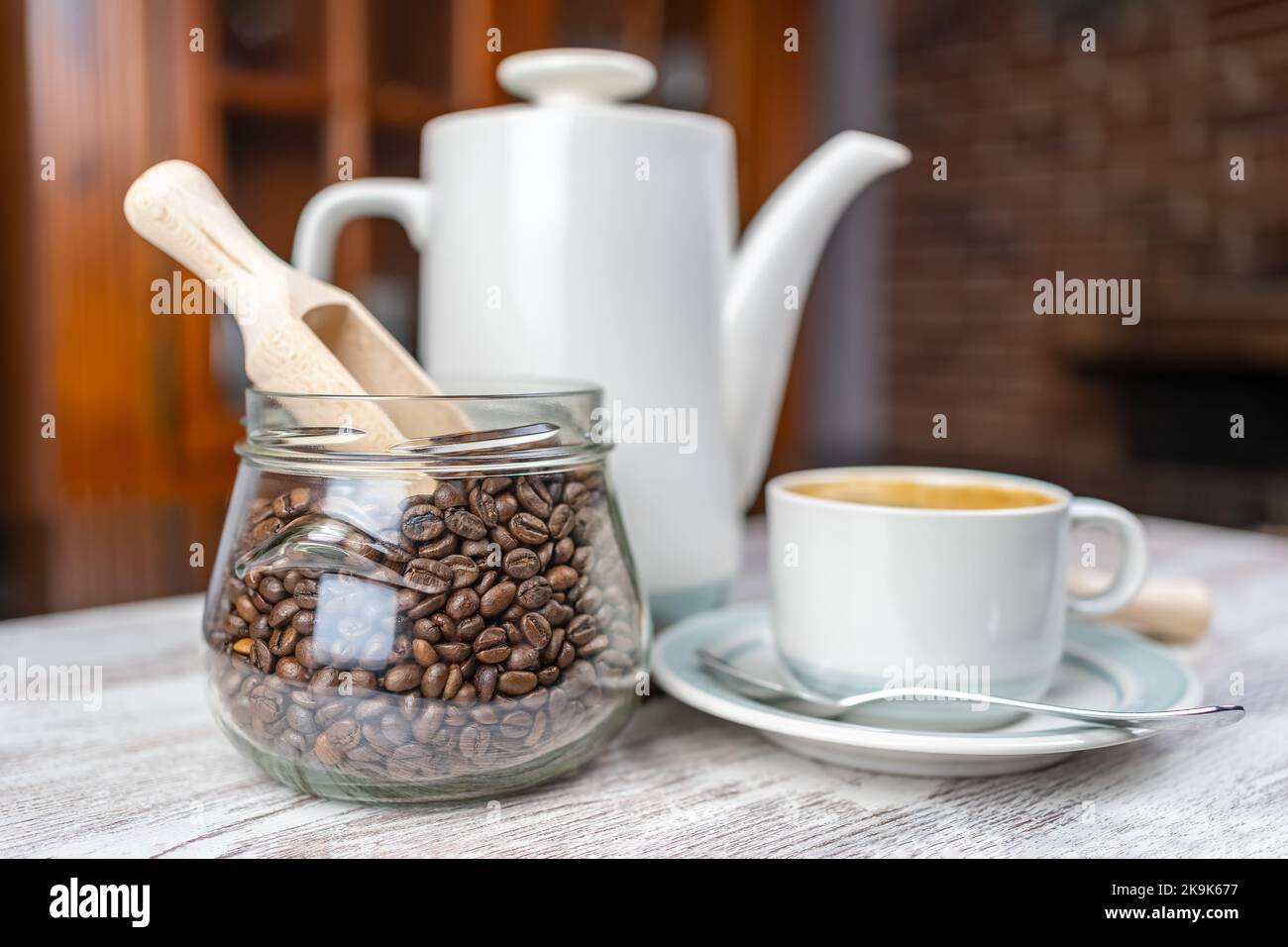 Kaffee-Set mit einer Tasse frisch gebrühten Kaffee, einer Porzellankaffeemaschine und einem Glas mit Kaffeebohnen. Stockfoto