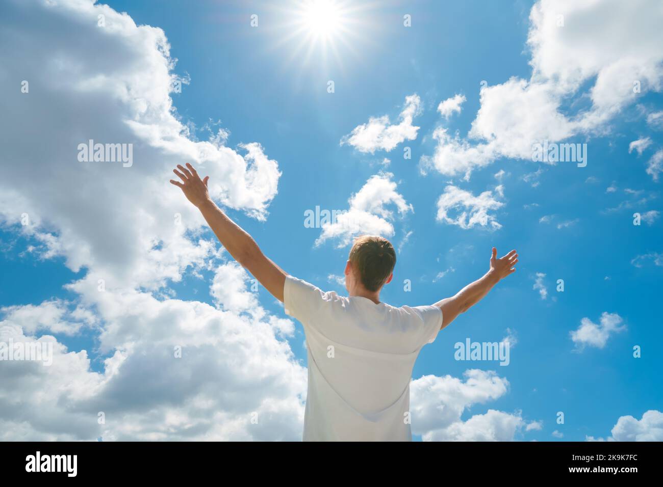 Der Mensch strebe die Hände nach dem tiefblauen Himmel und der Sonne. Religion und konzeptuelle Szene. Anbetung vor Gott. Stockfoto