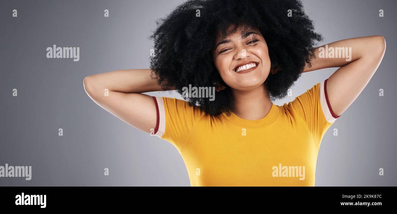 Bei solchen Haaren kümmerte ich mich nicht darum. Studioaufnahme einer attraktiven jungen Frau, die vor grauem Hintergrund posiert. Stockfoto