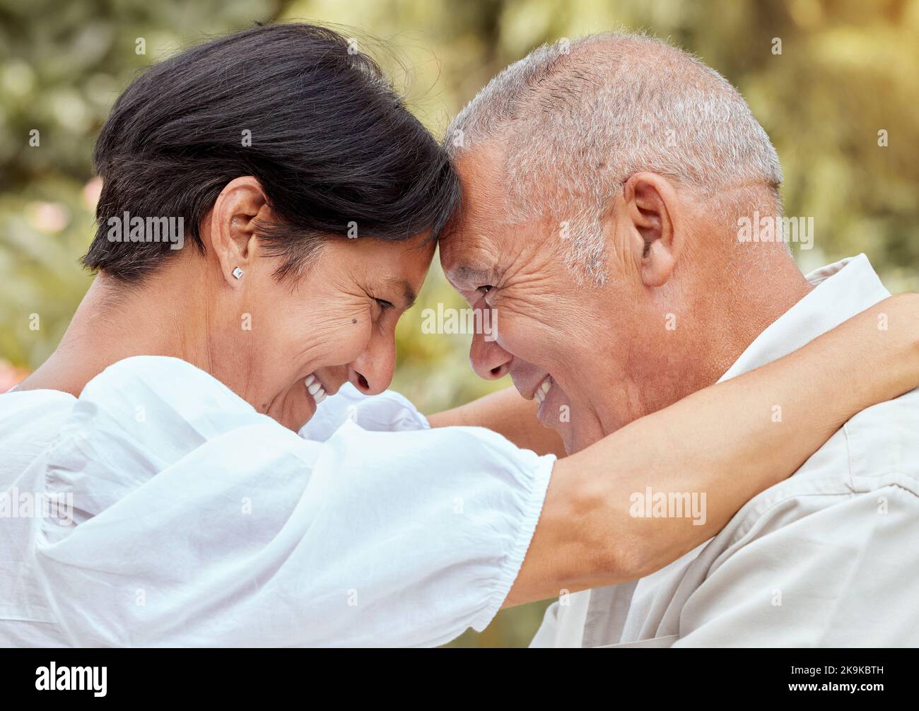 Seniorenpaar, Umarmung und Stirn mit Lächeln für Liebe, Romantik und Umarmung in Beziehung Glück im Freien. Glücklich reifen Mann und Frau umarmt Stockfoto