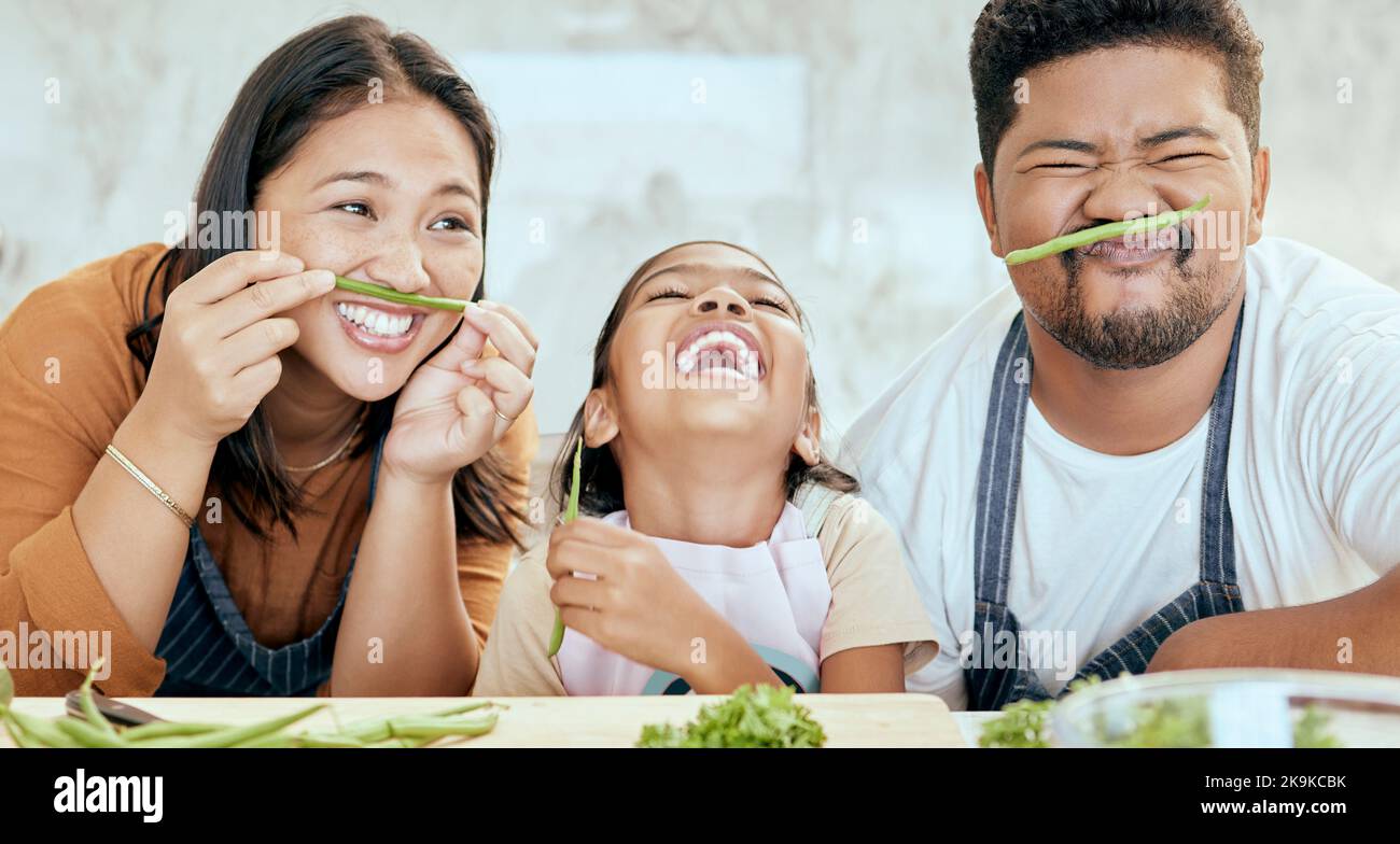 Glückliche asiatische Familie, spielen Gemüseküche im Porträt und lächeln zusammen am Tisch für die Verklebung Zeit. Mama Papa, Kind Glück in Comic-Home und Stockfoto