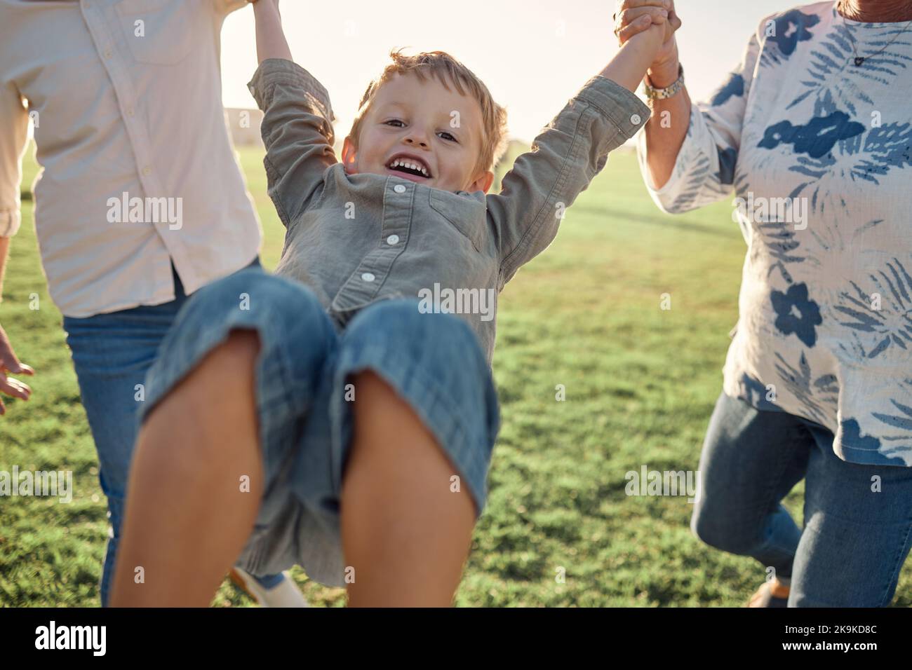 Glücklich, Gras und Kind, das die Hände mit den Eltern auf der Natur hält, gehen auf dem Feld in den Sommerurlaub. Familie, Unterstützung und Liebe, Glück in Spaßqualität Stockfoto