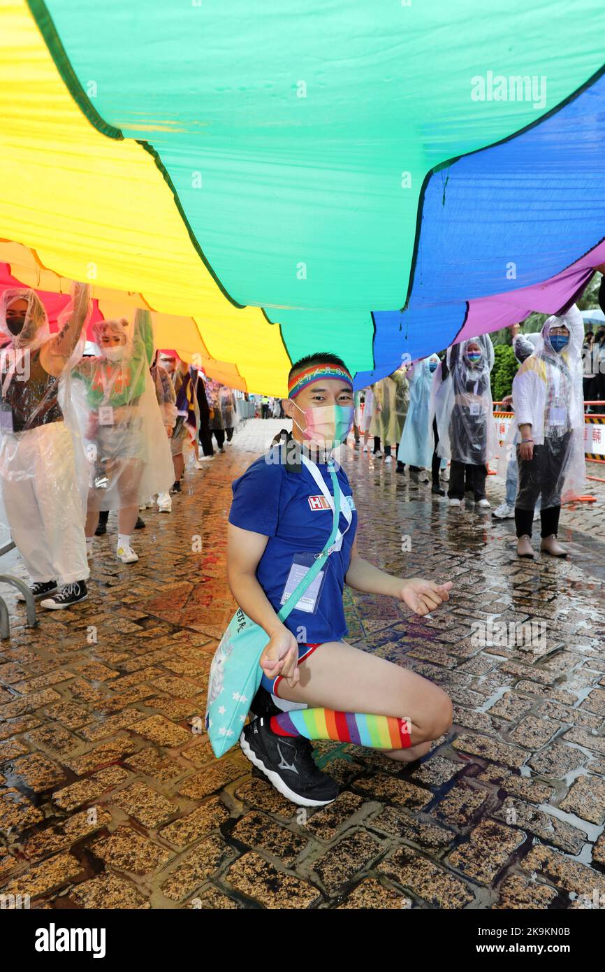 Taipeh, Taiwan. 29. Oktober 2022. Teilnehmer mit der riesigen Regenbogenfahne bei der Taipei LGBT Pride Parade, Taipei, Taiwan. Der 20.. Jahrestag der Parade fand trotz Regen statt und die Teilnehmer trotzten den Elementen meist mit Regenschirmen, was aber die Stimmung und den Spaß nicht dämpfte. Zehntausende nahmen an der Parade Teil, die auf einem Rundweg vom Rathaus von Taipei im Schatten von Taiwans höchstem Gebäude, Taipei 101, stattfand. Taiwan ist das fortschrittlichste aller asiatischen Länder, wenn es um LGBT-Rechte geht, und war das erste asiatische Land, das gleichgeschlechtliche Ehen rechtlich anerkannte. Cred Stockfoto