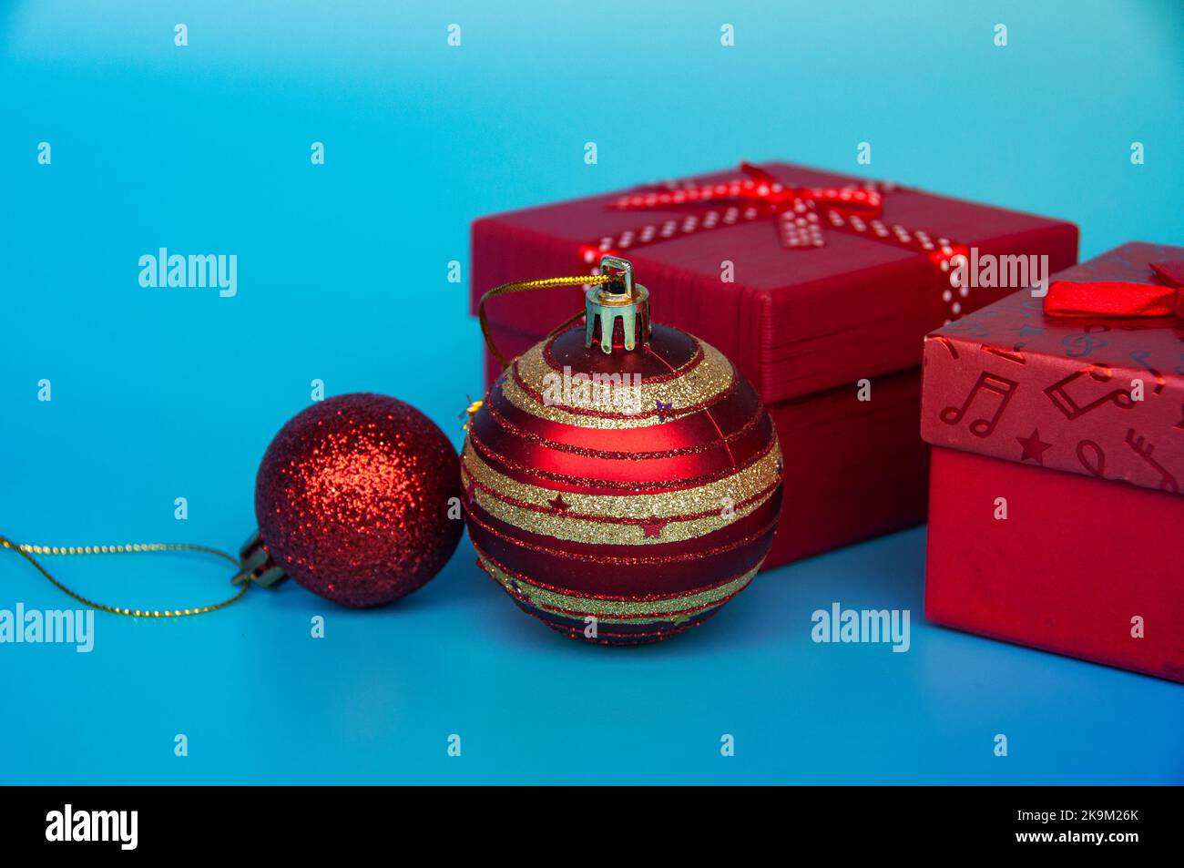 Weihnachtsgeschenke und -Kugeln auf hellblauem Hintergrund. Weihnachtsfeier Konzept. Stockfoto