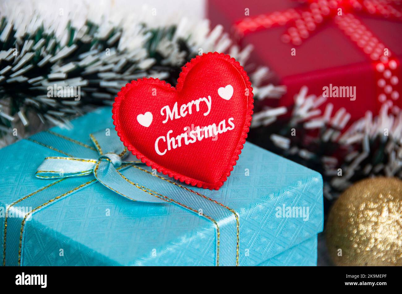Frohe Weihnachten Wünsche auf rote Herzform auf Weihnachtsgeschenk. Weihnachtszeit-Konzept. Stockfoto