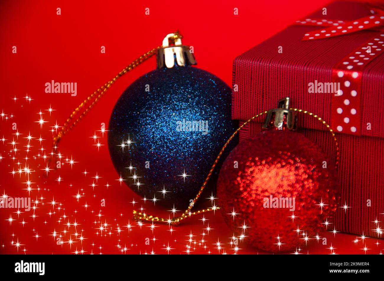 Weihnachtsgeschenke und -Kugeln auf hellrotem Hintergrund. Weihnachtsfeier Konzept. Stockfoto