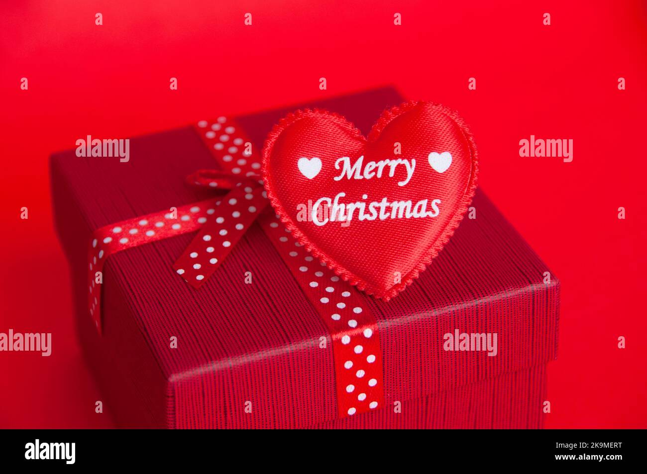 Frohe Weihnachten Wünsche auf rote Herzform auf Weihnachtsgeschenk. Weihnachtszeit-Konzept. Stockfoto