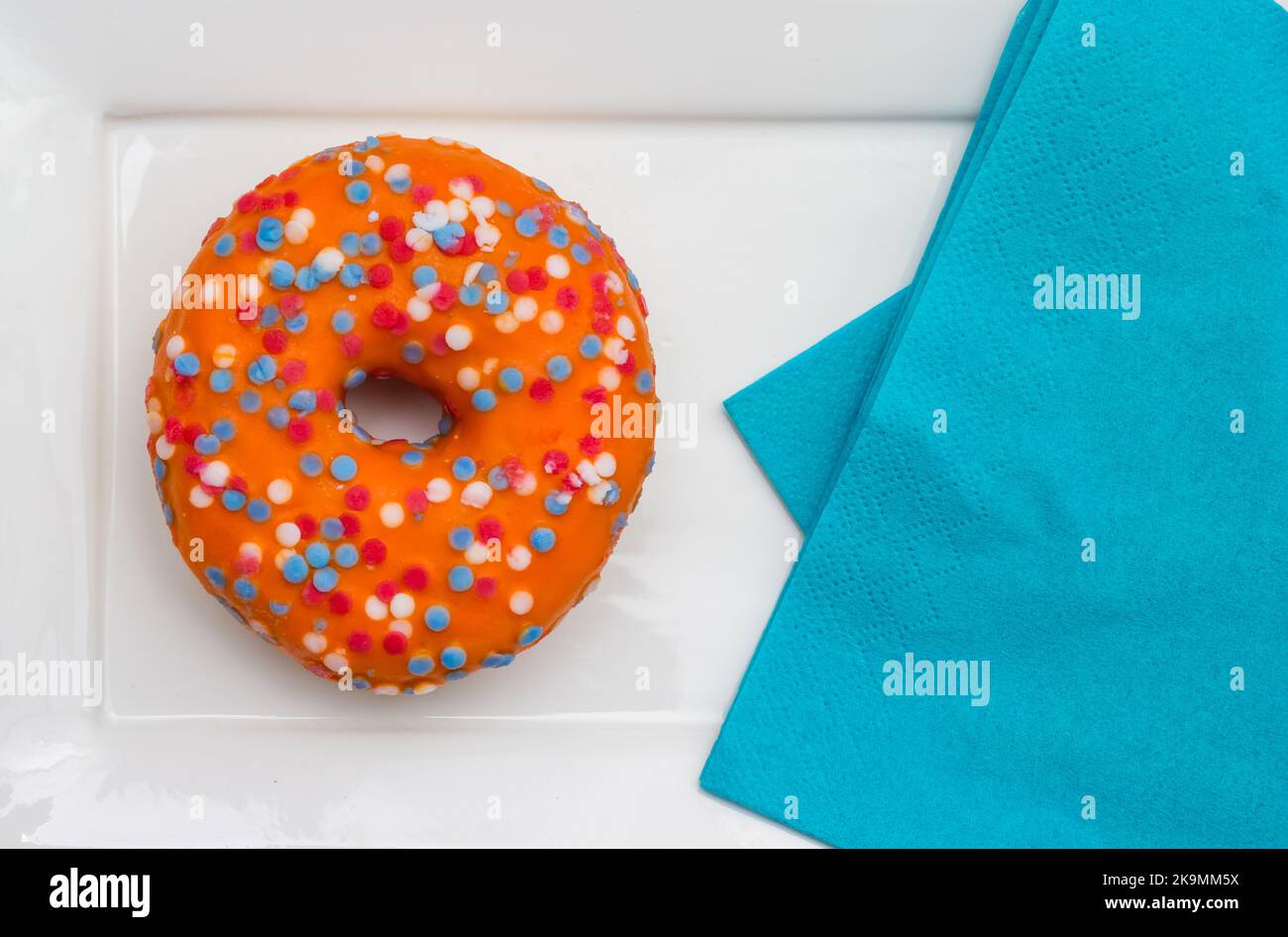 Orangefarbener Donut mit Streuseln in den Farben der niederländischen Flagge zur Feier des Koningsdag-Feiertags Stockfoto