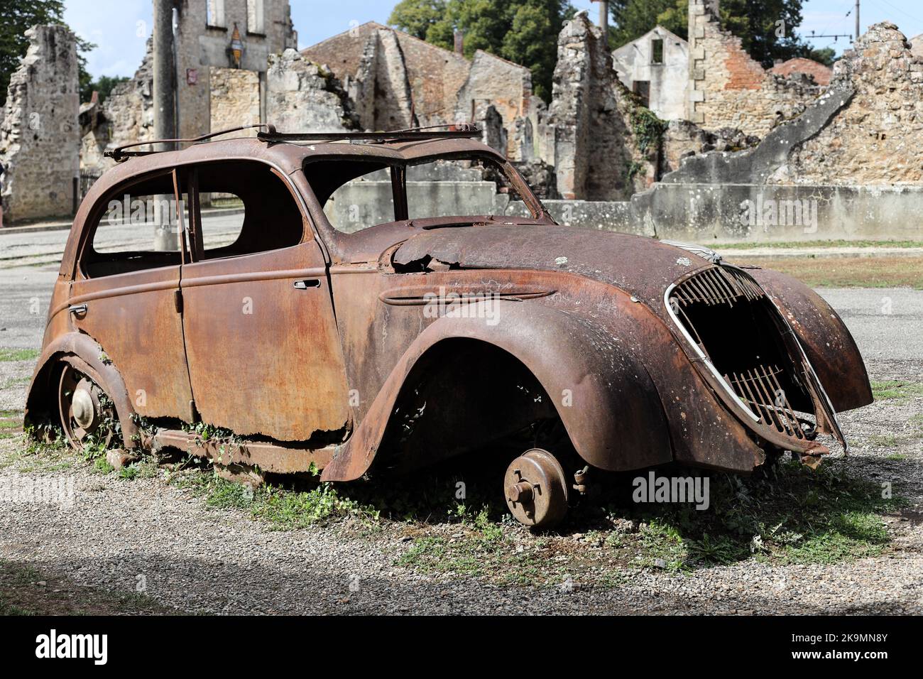 Die Überreste eines zerstörten Peugeot 202 Autos im Dorf Oradour-sur-Glane in der Haute-Vienne, Frankreich Stockfoto