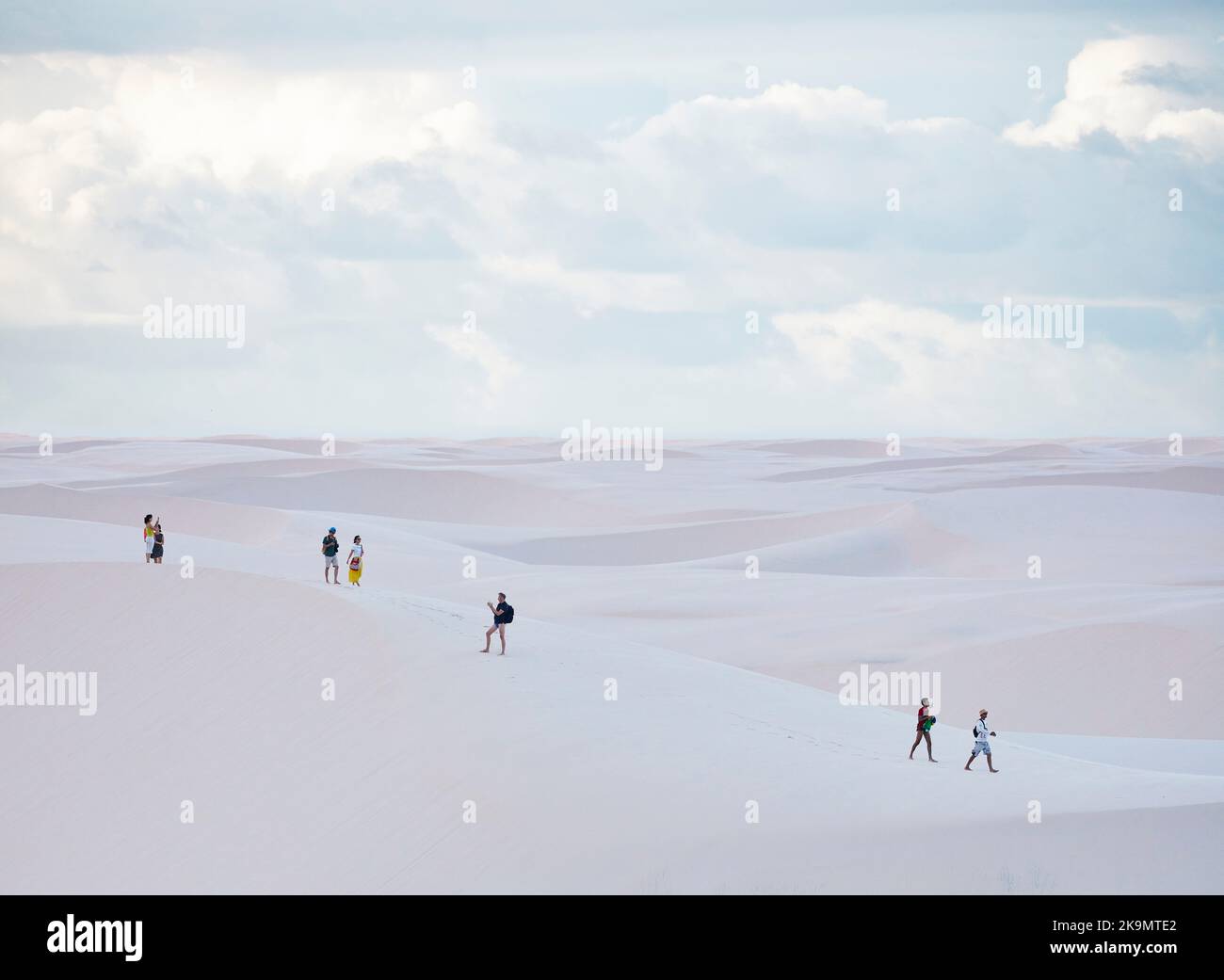Menschen, die durch Sanddünen laufen Stockfoto