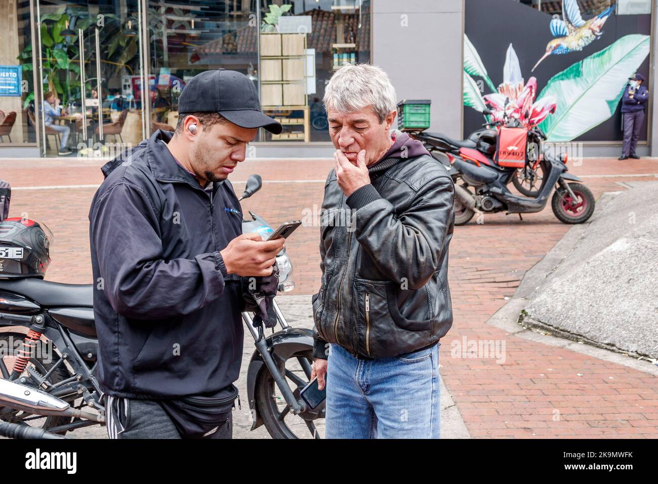 Bogota Kolumbien,Usaquen Avenida Carrera 7,Mann Männer Mann Vater Erwachsene Sohn Smartphone Smartphones Smartphone Handys Handy mit SMS lesen ch Stockfoto