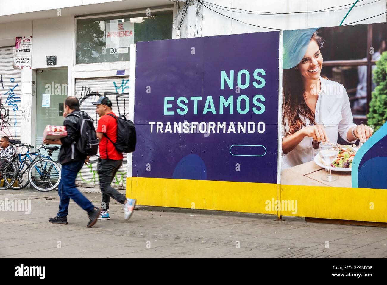 Bogota Kolumbien, Chapinero, Mann Männer männlich, Schild Werbetafel Informationen Förderung Werbung wirtschaftliche Entwicklung, Fußgänger zu Fuß Stockfoto