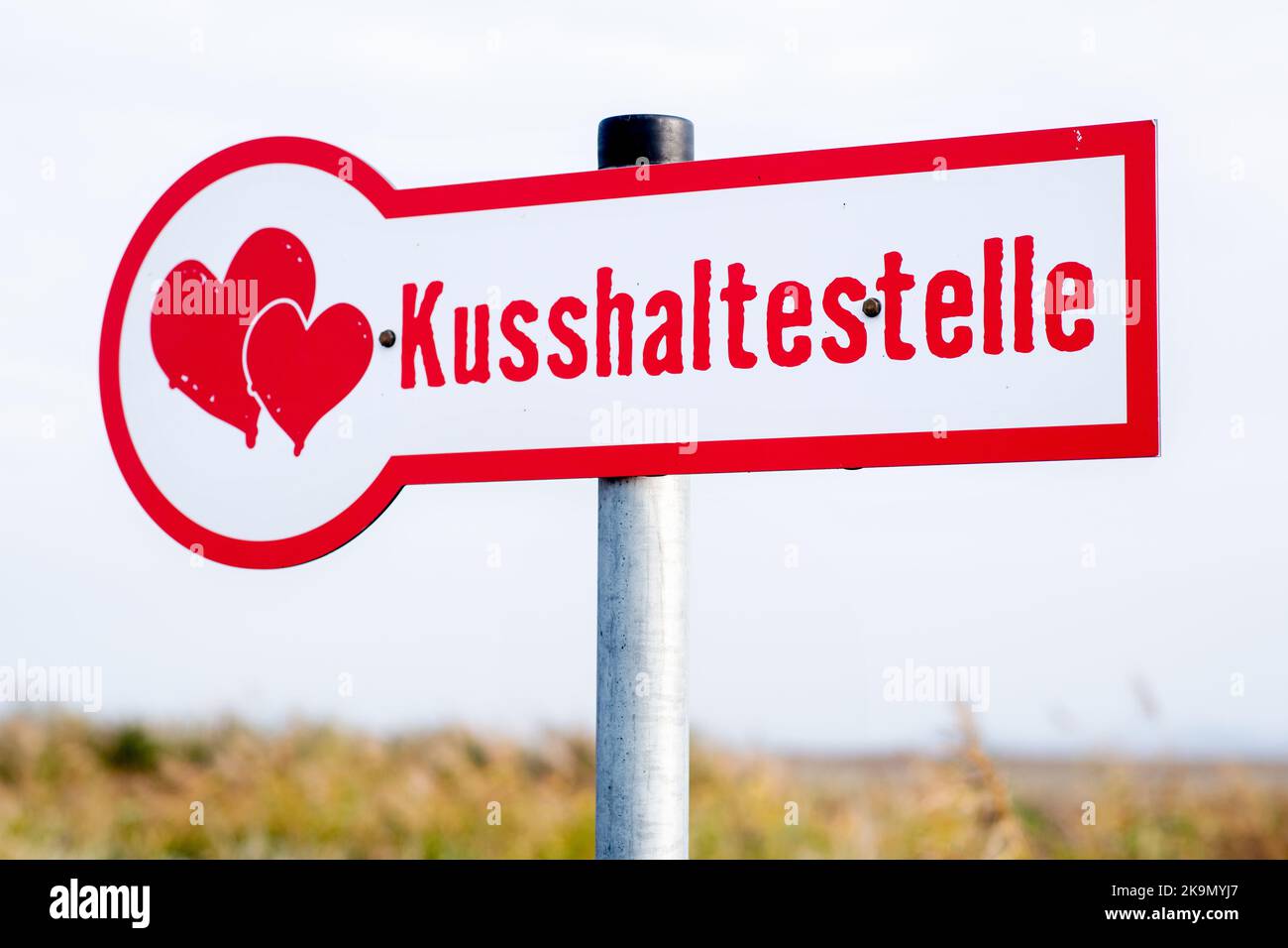 Wangerland, Deutschland. 29. Oktober 2022. Ein Schild mit der Aufschrift 'Kissing stop' steht in einem Feld neben einem Drahtgeflecht, das für sogenannte Liebesschlösser bestimmt ist. In der Nähe des Dorfes Bassens in der Gemeinde Wangerland können Liebhaber in diesem Rastplatz am Straßenrand für einen Kuss und gemeinsame Momente anhalten und sich mit einem von ihnen mitgebrachten Liebesschloss verewigen. Quelle: Hauke-Christian Dittrich/dpa/Alamy Live News Stockfoto