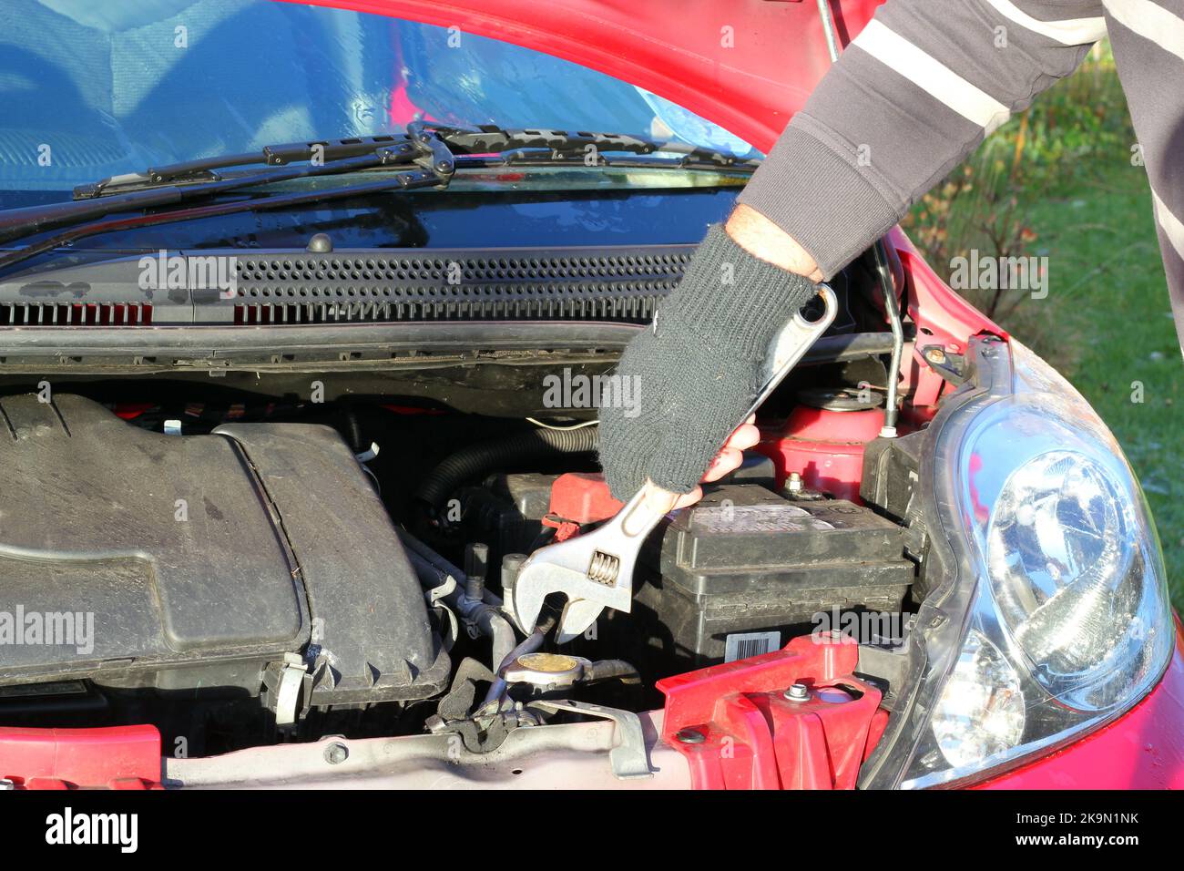Mechaniker, der ein Auto arbeitet. Mit dem Schraubenschlüssel am Motor. Stockfoto
