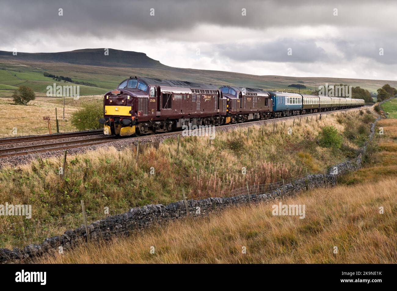 Zwei Oldtimer-Diesel der Klasse 37s führen eine Bahntour am Gipfel von Pen-y-ghent auf der Settle-Carlisle-Linie in Ribblesdale im Yorkshire Dales National Park vorbei. Stockfoto