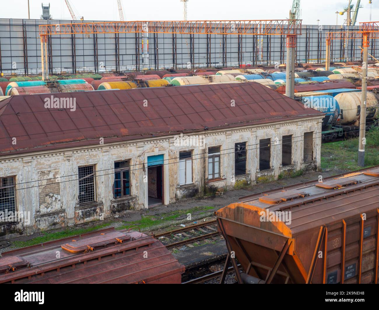 Altes verlassene Bahnhofsgebäude. Gruselige Orte. Sonnenuntergang am Bahnhof. Der Ladeteil des Bahnhofs ist eine Industriezone vor dem Hintergrund o Stockfoto