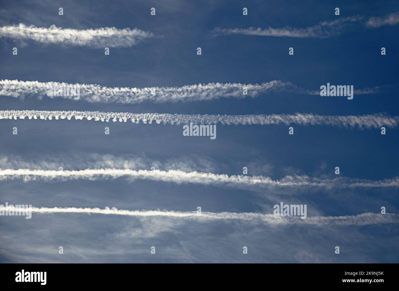 Hässlicher Himmel durch mehrere Kondensstreifen aus Flugzeugen verursacht. Massive Verunstaltung des Himmels durch Lufttourismus und Transport. Stockfoto