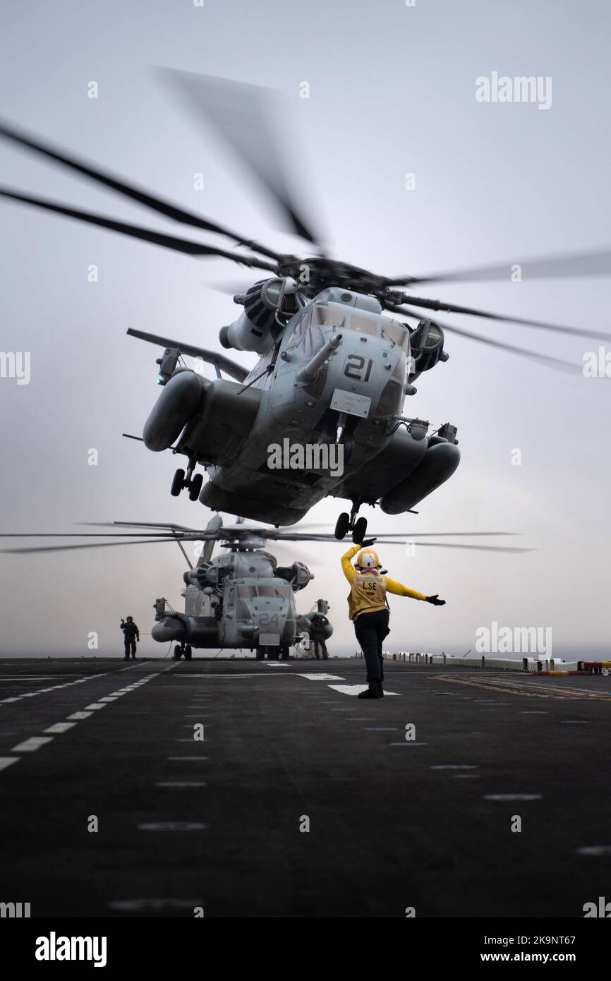 Der Flugzeugführer Mate (Handling) von Aviation Boatswain leitet einen Hubschrauber des Marine Corps CH-53 Super Henglion, der an die 22. Marine Expeditionary Unit (MEU) während des Flugbetriebs an Bord des amphibischen Sturmschiffs USS Kearsarge der Wasp-Klasse (LHD 3) befestigt ist. Stockfoto