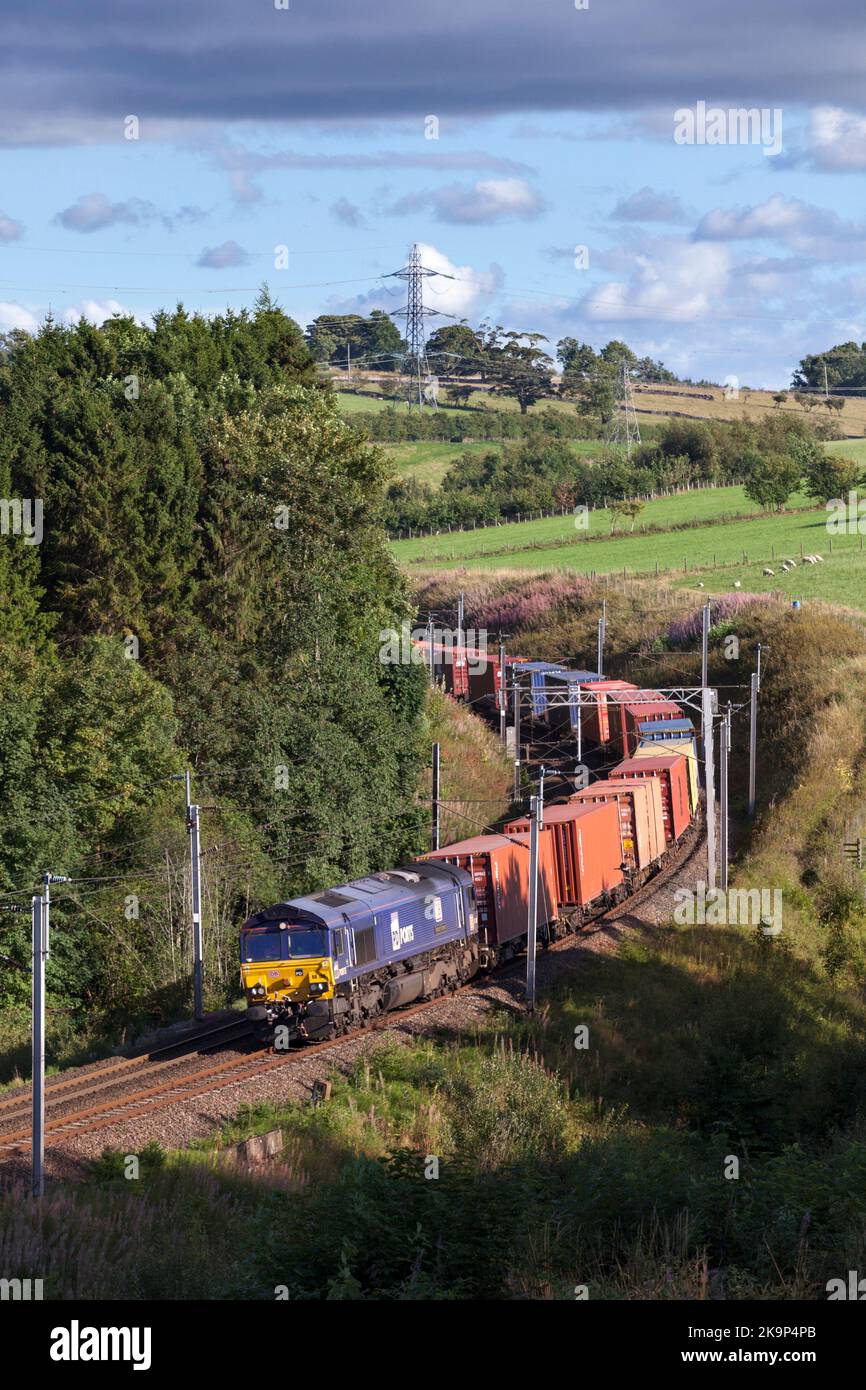 DIESELLOKOMOTIVE DB CARGO Klasse 66 auf der Hauptstrecke an der Westküste mit intermodalem Containerfrachtzug in der Landschaft von Cumbrien Stockfoto