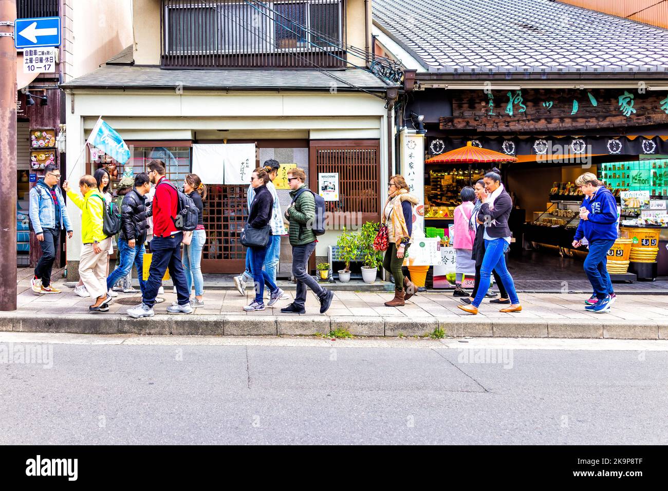 Kyoto, Japan - 11. April 2019: Geführte Reisegruppe mit Fremdenführer in der Altstadt von Kyoto in Arashiyama, Ukyo-Station zu Fuß auf dem Straßensteig Stockfoto