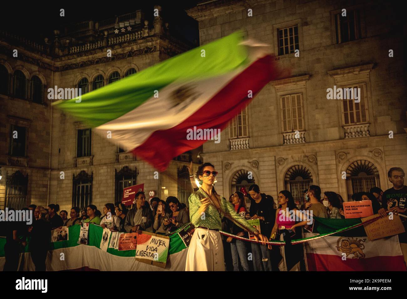 Barcelona, Spanien. 29. Oktober 2022. Eine Aktivistin schwenkt die iranische Flagge während einer Solidaritätsdemonstration mit Protesten im Iran, die seit dem Tod der 22-jährigen Mascha Aminiy ausgebrochen sind, als sie in Gewahrsam der sogenannten Moralpolizei war. Quelle: Matthias Oesterle/Alamy Live News Stockfoto