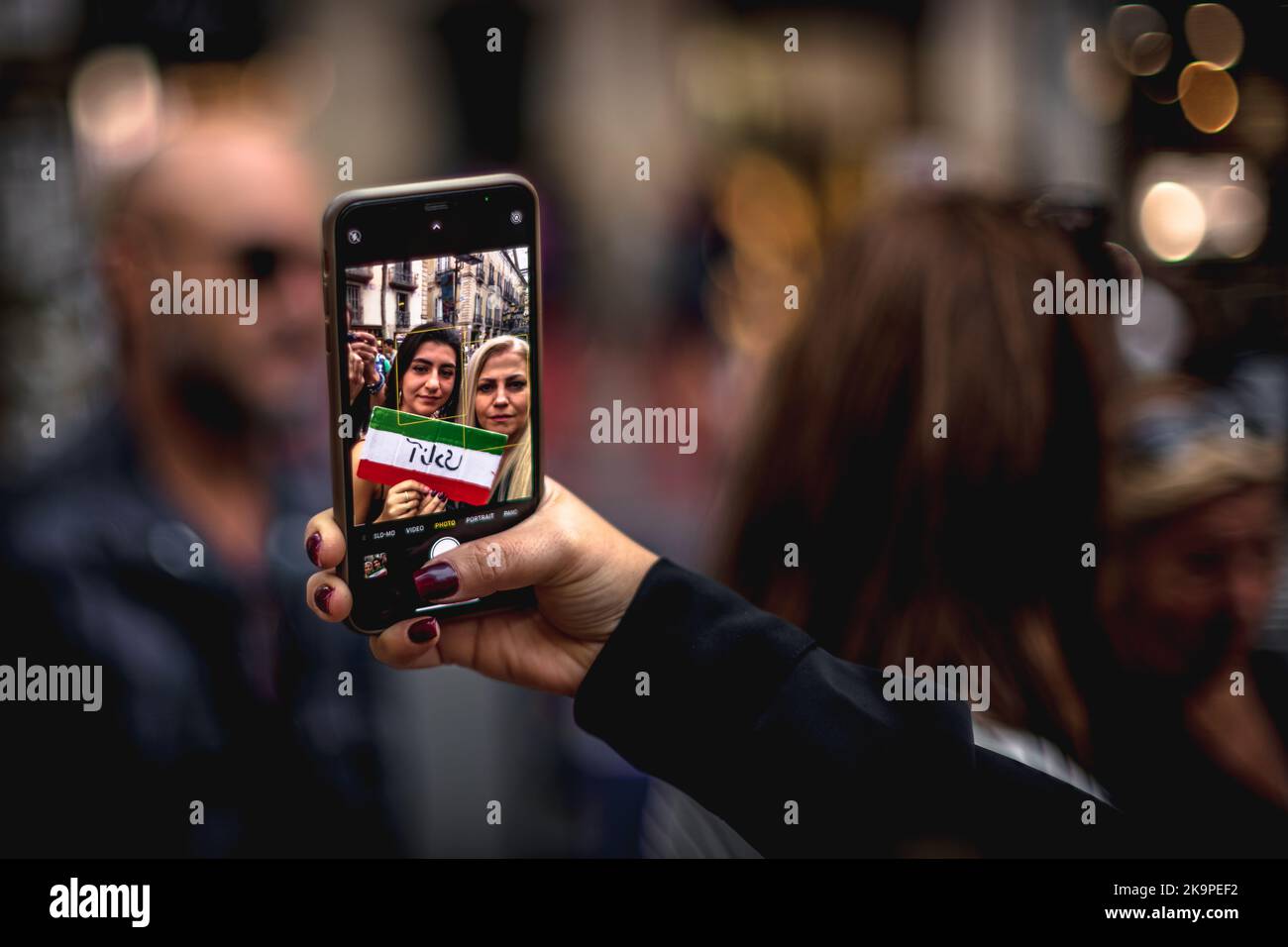 Barcelona, Spanien. 29. Oktober 2022. Zwei Demonstranten machen ein Selfie, während sie an einer Menschenkette teilnehmen, um sich solidarisch mit den Protesten im Iran zu zeigen, die seit dem Tod der 22-jährigen Mascha Aminiy in Gewahrsam der sogenannten Moralpolizei ausgebrochen sind. Quelle: Matthias Oesterle/Alamy Live News Stockfoto