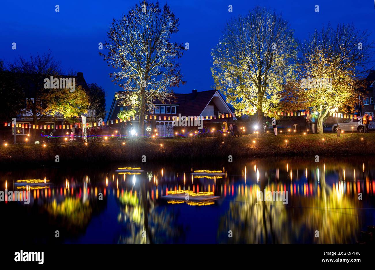 Horumersiel, Deutschland. 29. Oktober 2022. Zahlreiche bunte Laternen hängen an einer Linie um den natürlichen See Kolk im Stadtzentrum und spiegeln sich im Wasser. Hunderte von Laternen und Fackeln sowie schwebende Lichter in bunten Seerosen verwandeln den Kolk während der traditionellen Kolk-Beleuchtung in ein buntes Lichtermeer. Quelle: Hauke-Christian Dittrich/dpa/Alamy Live News Stockfoto