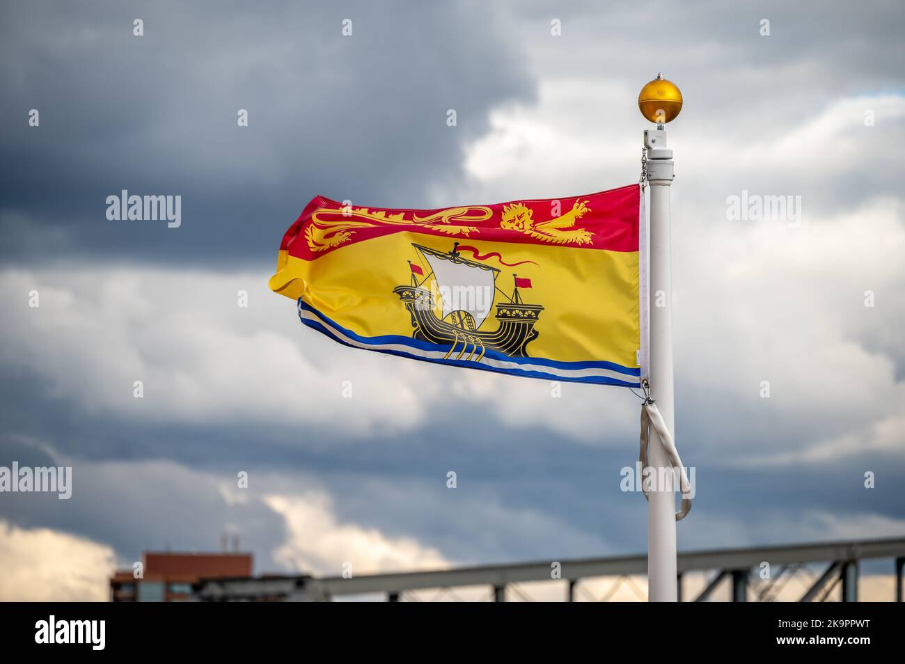 Die Flagge von New Brunswick verzichtet an einem bewölkten kanadischen Tag. Stockfoto